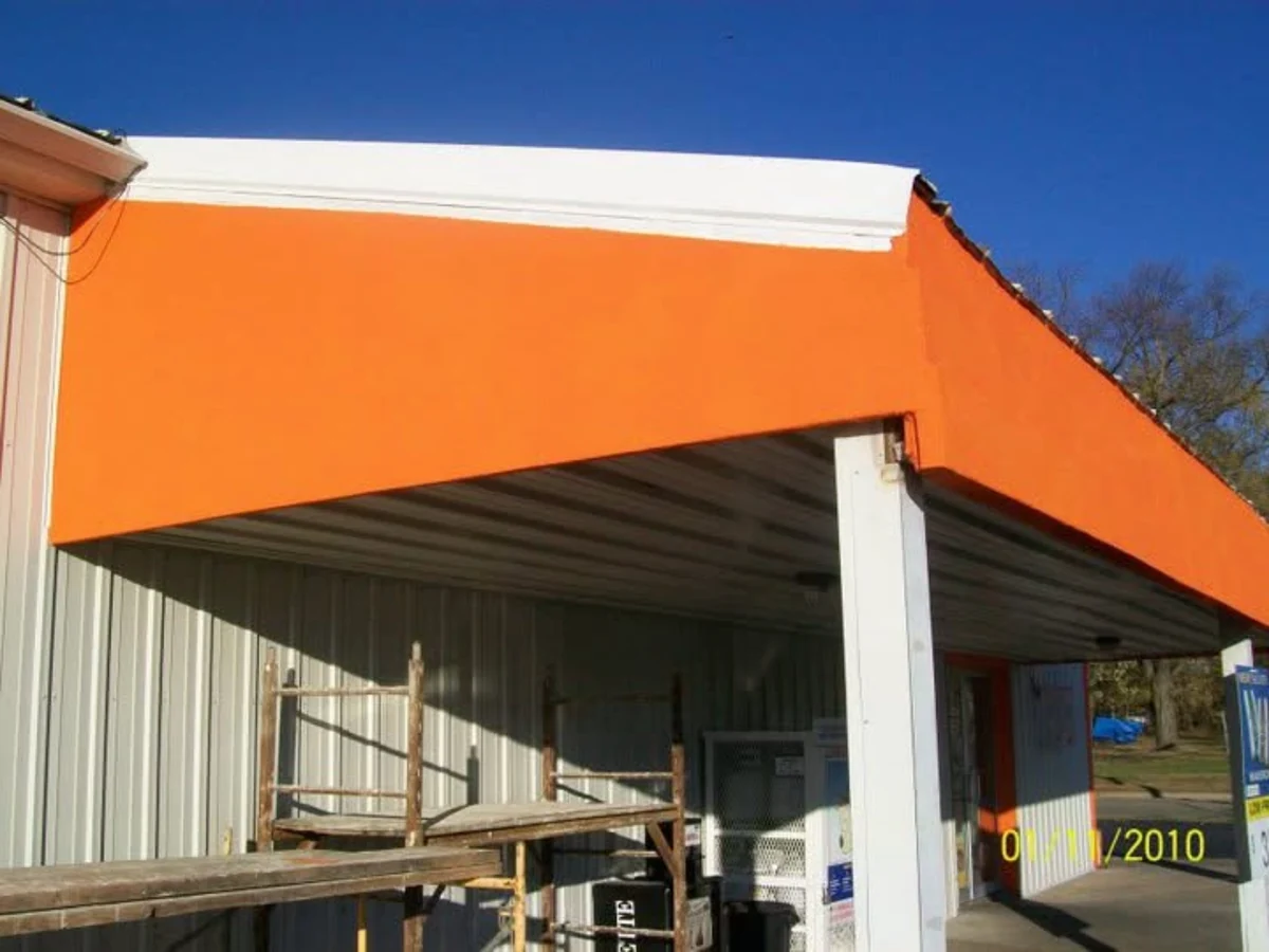 After: the same corner fascia rebuilt and finished in a smooth bright-orange exterior coating