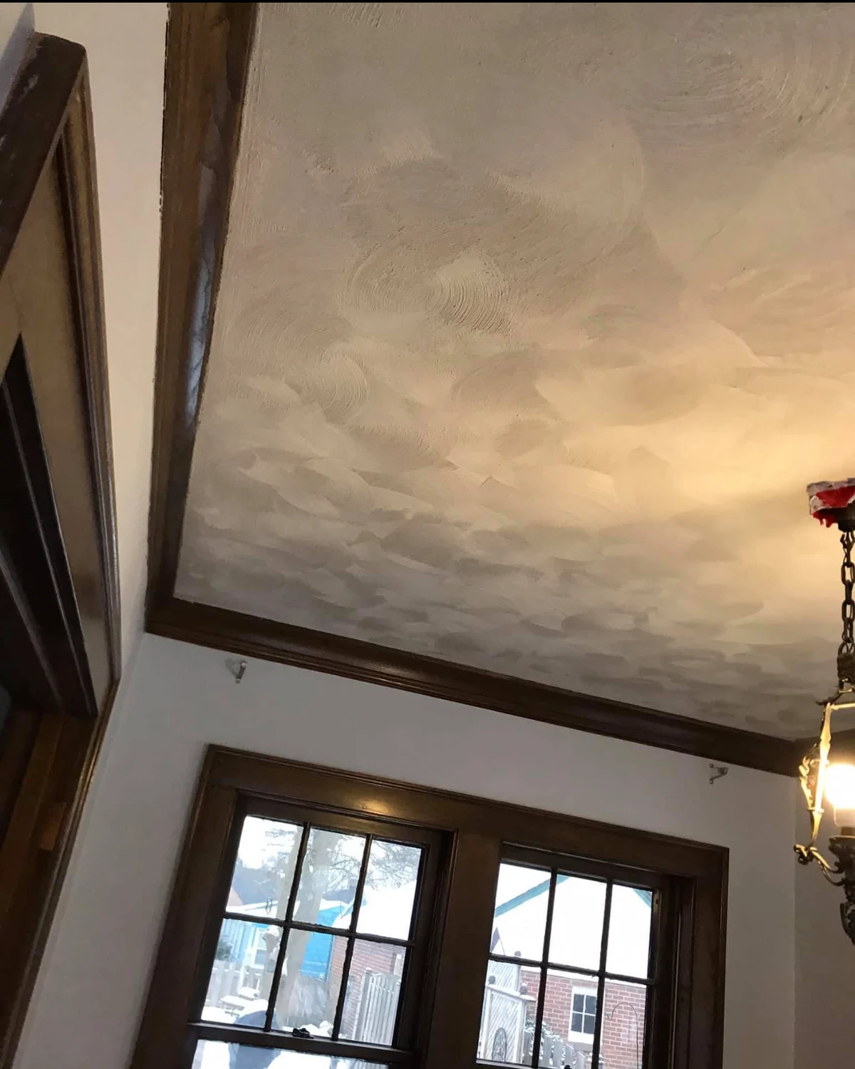 Finished textured calico ceiling above dark-trimmed windows, viewed across the room