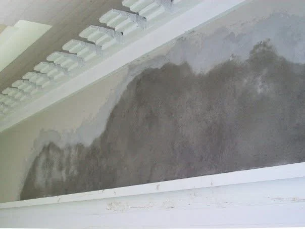 In progress: fresh stucco base coats applied across the soffit, still drying