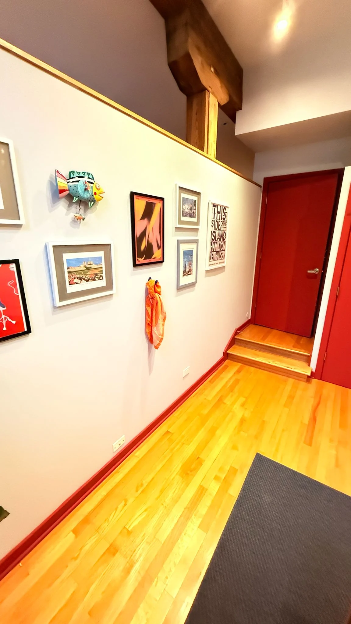 After: the same hallway with the door and baseboards painted a rich red