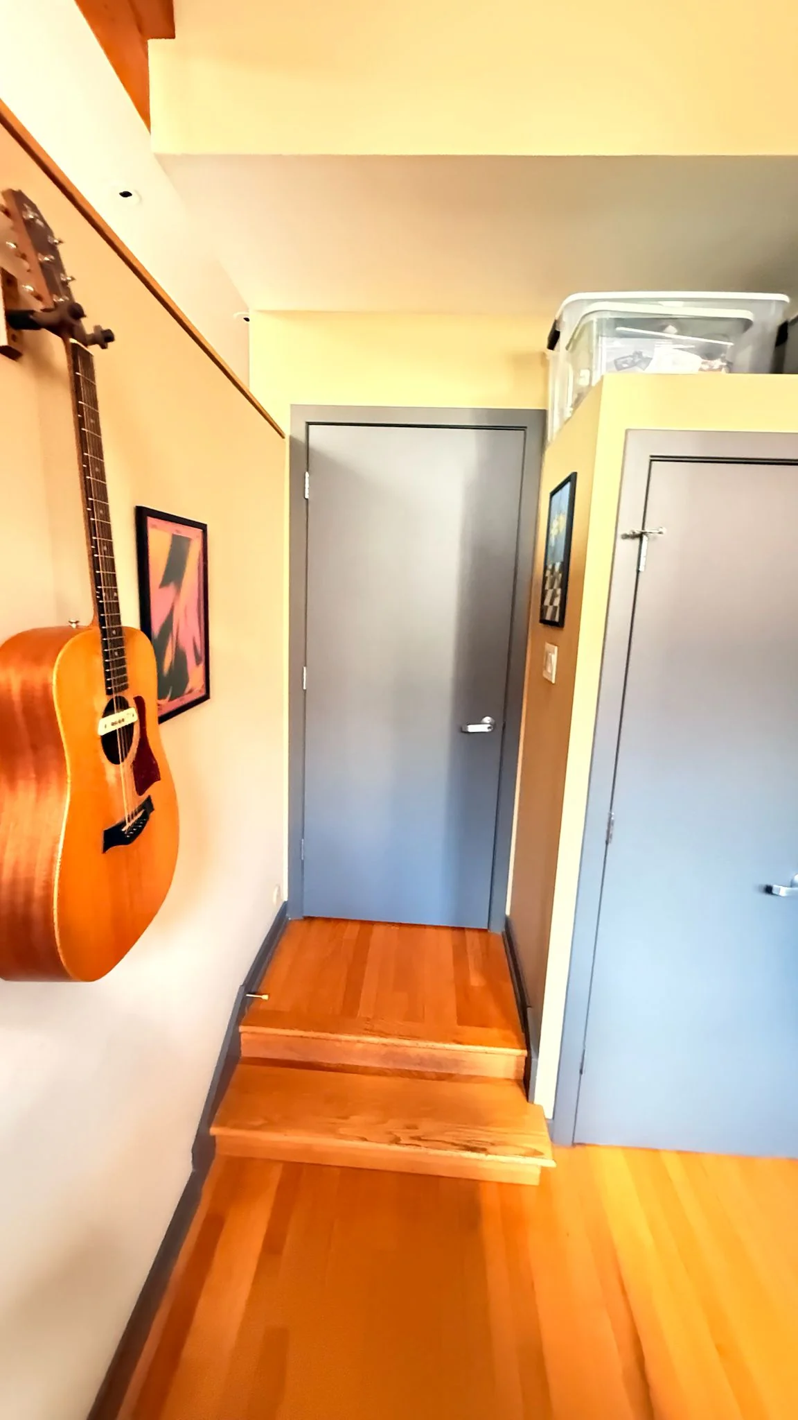 Before: a hallway leading up two steps to a plain gray door with gray trim
