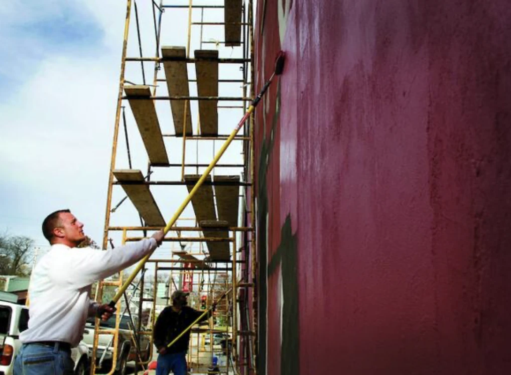 Our third-generation plasterer finishing a stucco and painting job on a commercial building in Morrison, Illinois