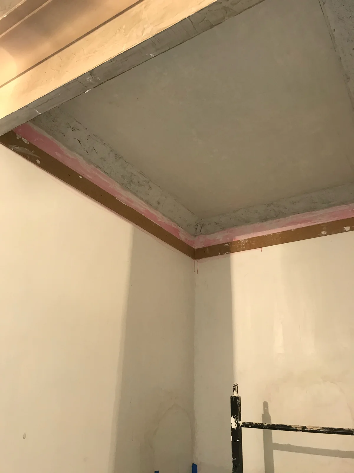 A plaster ceiling and cove mid-restoration, saved rather than torn out